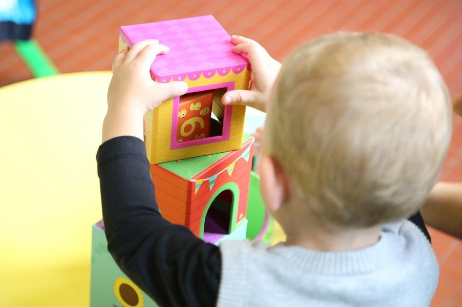 Stock image of a child playing with bricks, illustrating how play helps child development - Rowans Day Nursery in Sutton Coldfield