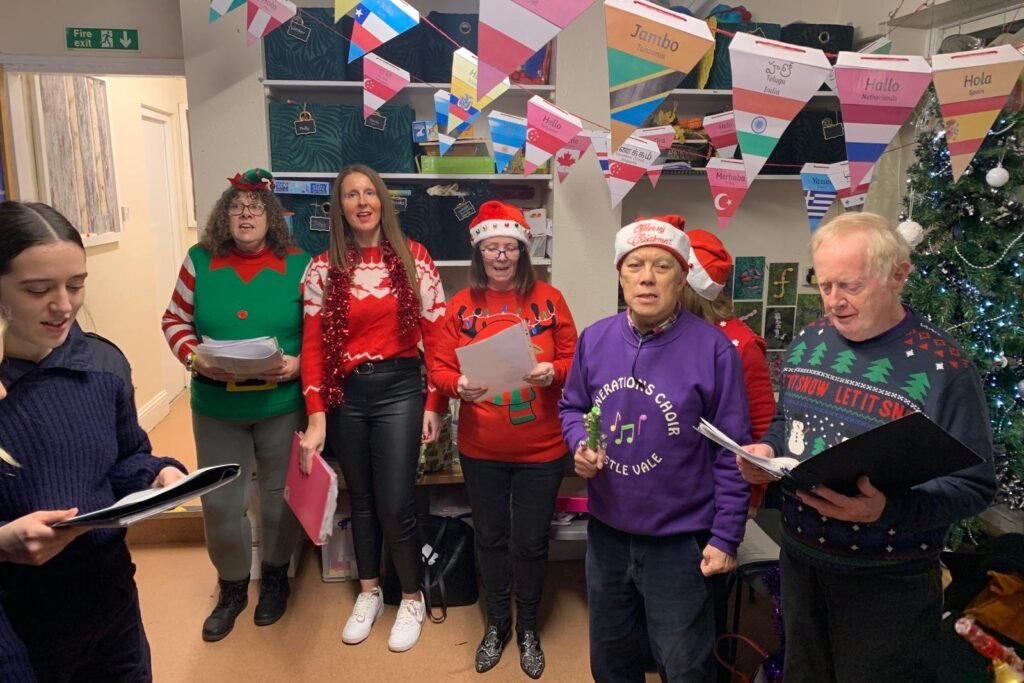A choir singing Christmas carols at a Rowans Day Nursery Christmas fete